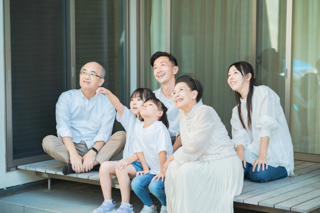 三世代家族のだんらんイメージ。縁側に集まる家族。